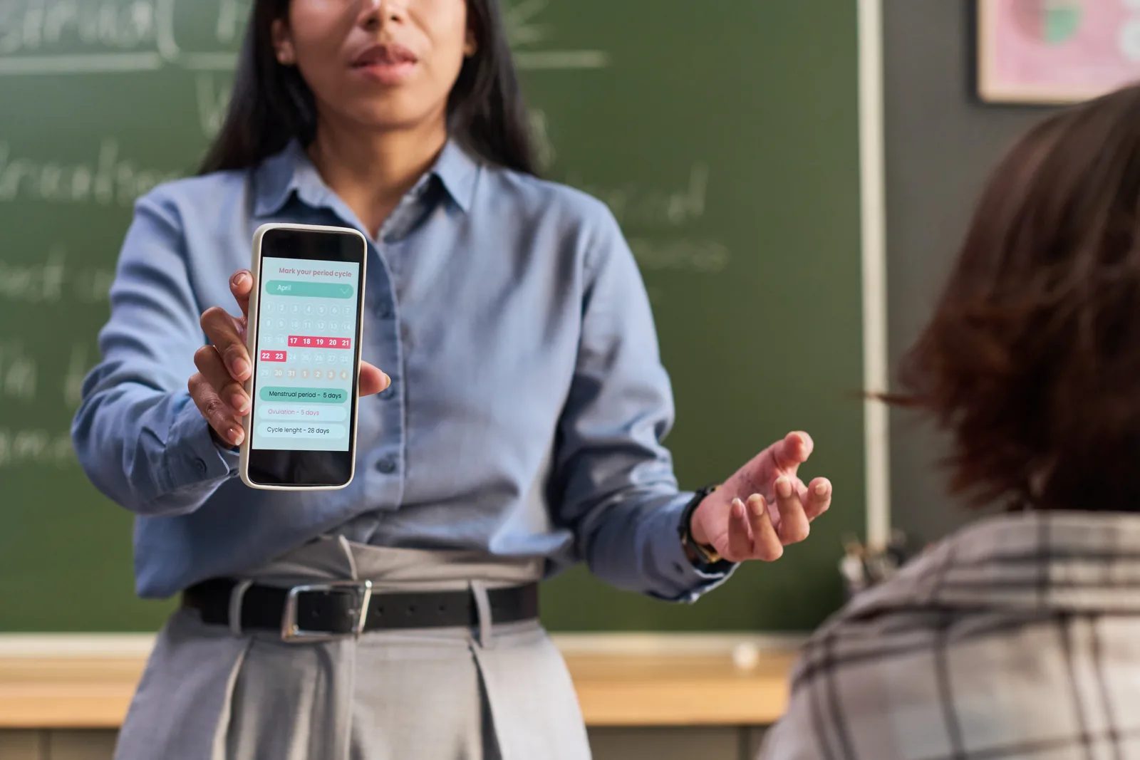 Teacher holding up a student's phone in a classroom