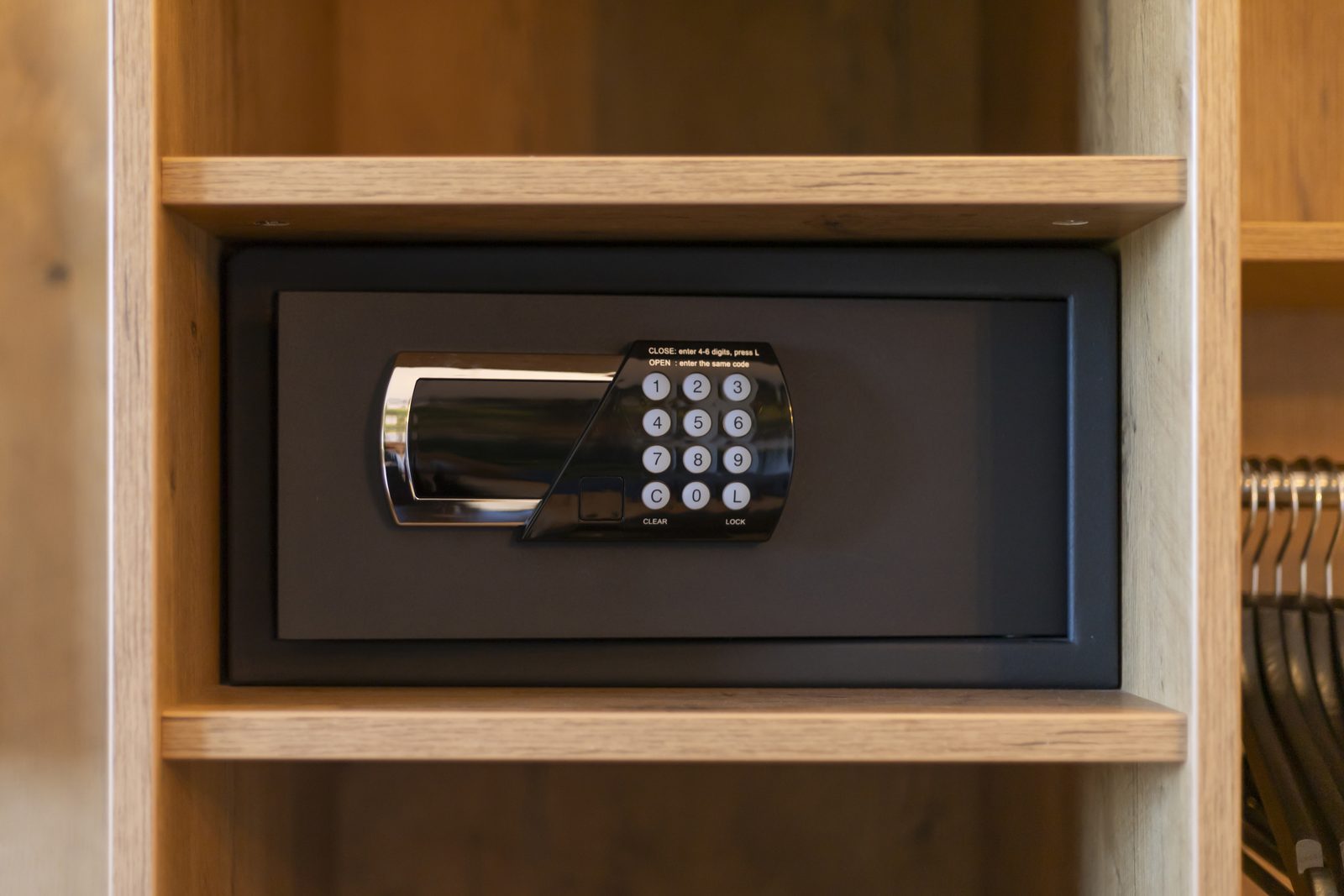Small keypad lock safe built into a wooden closet shelf