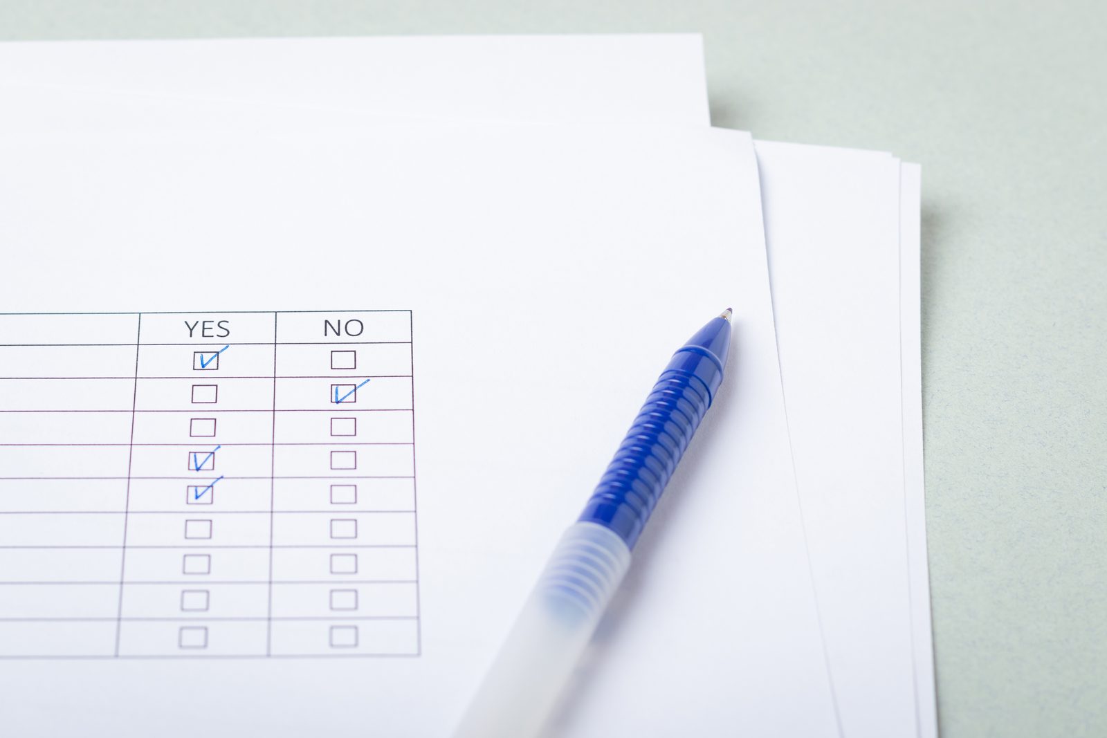 Printed questionnaire with yes and no checkboxes and a blue pen